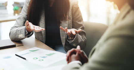 Hands, business people and discussion with feedback, graphs and profit growth or sales analytics. Closeup, teamwork and financial advisor with proposal, advice or ideas for charts or company revenueの写真素材