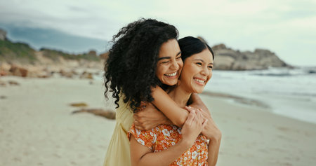 Love, hug and date with lesbian couple at beach for romance, vacation and support. Happiness, bonding and lgbt relationship with women and embrace in nature for summer break, holiday and honeymoonの写真素材