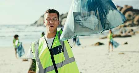 Man, portrait or volunteer with bag on beach for recycling, eco friendly environment or earth day. Male person, activist or community service with garbage or dirt for save planet or world charityの写真素材