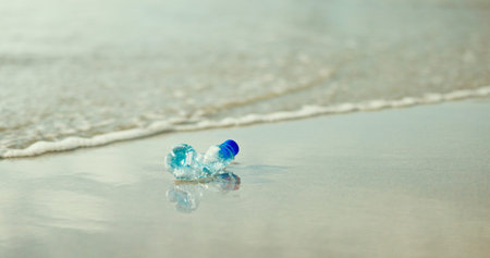 Plastic bottle, beach and pollution in nature, water or outdoor on ground with dirt in environment....