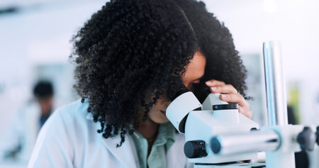 Microscope, woman and scientist in laboratory with studying cell function for RNA development. Biotech, medical research and geneticist with equipment for DNA vaccine, pharmaceutical or immunology.の写真素材
