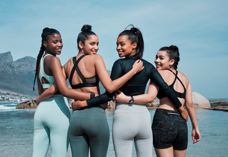Back, happy or women and hug at beach for fitness, exercise and adventure in water. Love, support and friends or teamwork by sea in nature for workout, training or together with care in morningの写真素材