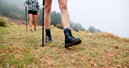 Trekking pole, feet and walking on mountain for travel adventure, cardio workout and expedition. Fitness, shoes of people and hiking with balance outdoor for holiday exploration, exercise or wellnessの写真素材