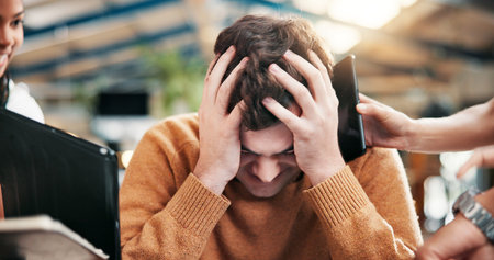 Frustrated, headache and man in office with multitasking for project deadline or demanding employees. Male person, chaos or overworked with stress, anxiety or overwhelmed for workload or pressureの写真素材