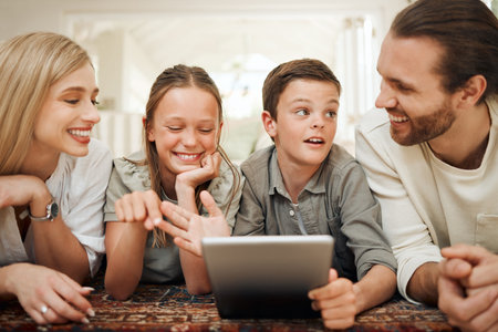 Family, children and tablet with internet, smile and parents watching cartoon on living room floor...