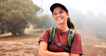 Happy, hiking and portrait of woman in nature for adventure, exploring or discovery on holiday. Excited, confident and female person from Australia on trekking and backpacking trip outdoor in forest.の写真素材