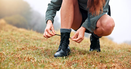 Boots, hiking and woman tie laces outdoor for activity, exploring or adventure on holiday. Fitness,...