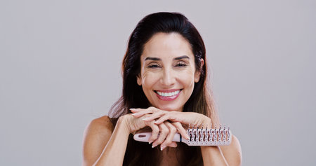 Cosmetics, portrait and woman with hairbrush in studio for natural growth, scalp stimulation and...