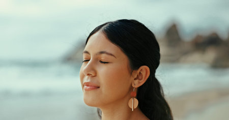 Woman, meditate or peace to relax at sea with fresh air for break, tranquility or natural oxygen. Calm, health or person on holiday at beach or ocean coast for vacation travel and outdoor freedomの写真素材