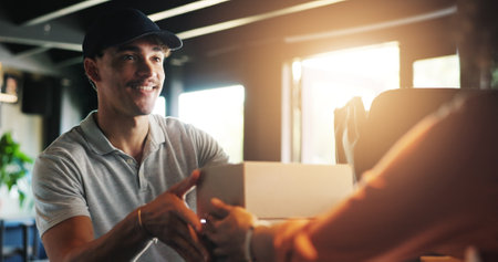 Man, barista and restaurant for delivery with box for catering service, food or sale at diner. People, courier or customer giving order for collection, meal or small business at cafe or coffee shopの写真素材