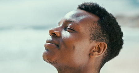 Black man, peace and breathing to relax with fresh air at beach for break, tranquility or natural...