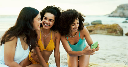 Beach, phone and smile with friends on holiday together for travel or vacation in summer. App, bonding and social media with group of people outdoor on coast of tropical island paradise for getawayの写真素材