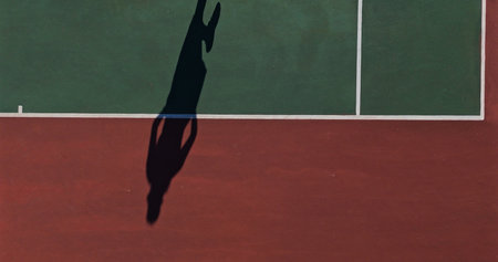 Shadow, tennis court and player with training for match, challenge or championship with sports. Fitness, practice and silhouette athlete on field for outdoor workout, game or exercise at competition.の写真素材