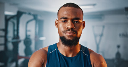 Portrait, fitness and serious black man in gym for exercise, muscle and strength training for health. Determination, face and person at workout club with confident bodybuilder or sports trainerの写真素材