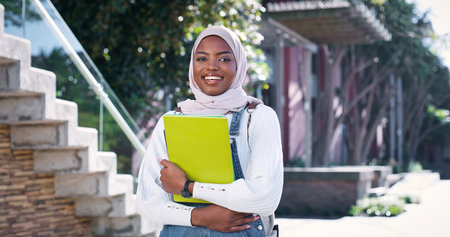 University, Muslim and portrait of woman on campus with smile, backpack or study opportunity in education. Culture, equality and happy college student in hijab on morning commute to learn in Rwandaの写真素材