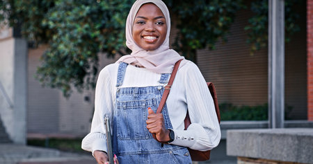 University, campus and portrait of Muslim woman with smile, backpack and study opportunity in education. Culture, equality and happy college student in hijab on morning commute for learning in Rwandaの写真素材