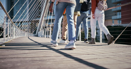 Feet, college and friends with people and walking for education, learning and knowledge. University, academy and youth development with students on campus for scholarship, school and studyingの写真素材