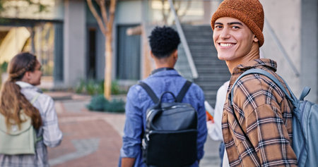 College, student and man in portrait outdoor on campus with book for education, learning and scholarship. Gen z, person or walking at university for studying, knowledge and backpack for exam researchの写真素材
