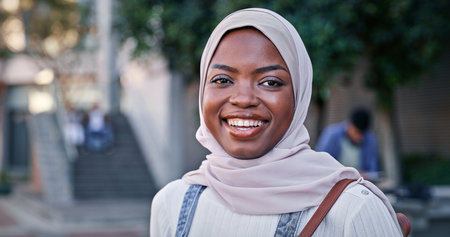 Muslim, girl and portrait on campus at university with smile, backpack and opportunity in education. Culture, equality and happy college student in hijab on morning commute for learning in Rwandaの写真素材