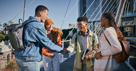 Education, handshake and group of friends, outdoor and greeting to classmate, campus and laughing. Bonding, holding hands and agreement for studying, books and students with smile, people and collegeの写真素材