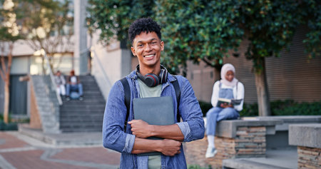 Student, smile and portrait at school for education, laptop and pride for academic achievement. Man, happy and headphones on campus for knowledge, development and university scholarship opportunityの写真素材