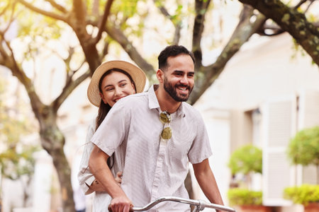 Happy couple, bicycle and travel with date in city for fun bonding, weekend or outdoor holiday. Young man, woman or tourists enjoying cycling, leisure or activity together on bike in urban townの写真素材
