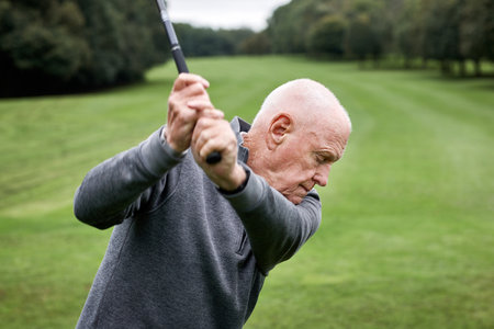 Golf, old man and swing on grass for game, sports club and playing for weekend hobby in retirement. Hit, course and person on green lawn for competition, outdoor challenge and senior golfer on field.の写真素材