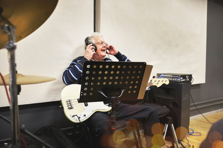 Man, recording studio and electric guitar for music album or rock song, listening or entertainment performance. Old person, string instrument and artist for rhythm sound hobby, creativity for melodyの写真素材