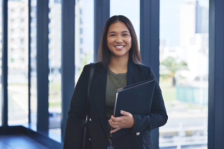 Portrait, employee and woman with documents, smile and confidence with career ambition, lawyer and portfolio. Face, person or professional with paperwork, attorney or legal aid with proposal or prideの写真素材