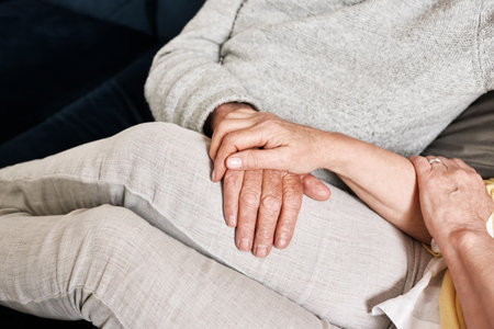 Senior couple holding hands for love, support and trust for gratitude, empathy and care in retirement at home. Closeup, partner and helping hand for loyalty, kindness and relax together in marriageの写真素材
