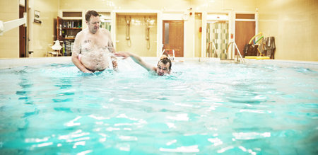 Water, pool and swimming with a boy learning how to swim with his dad teaching him the freestyle....