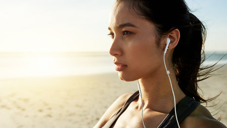 Exercise, beach and thinking with woman prepare for running, workout and summer goal with music. Athlete, warm up or ready to start jog for fitness, endurance or health for wellness sport trainingの写真素材