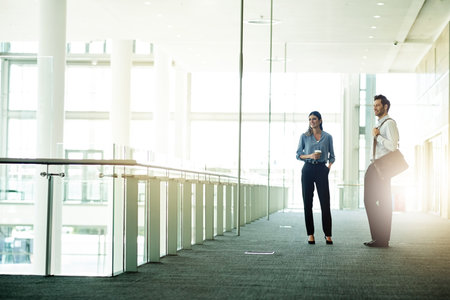 Business, people and talking in modern office in morning for company gossip, work break or friendly chat. Professional, employees or conversation at finance firm for networking or waiting for meetingの写真素材