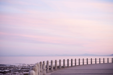 Sunset sky, space and promenade at ocean for travel, horizon view and low tide in Brazil. Evening,...
