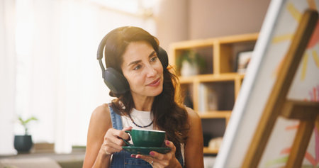 Woman, artist and coffee with headphones for painting, listening to music and art project. Person,...