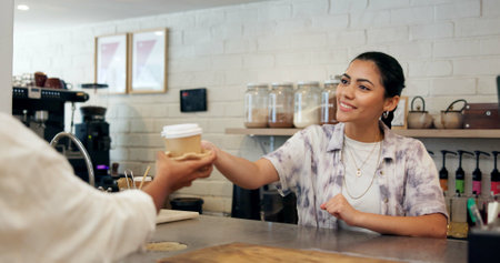Cafe, barista and woman with coffee, serving and smile for customer service, giving and hospitality. Small business, waitress and person with latte for consumer, happy and checkout for takeawayの写真素材