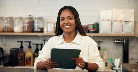 Smile, portrait and woman on tablet at cafe for menu update, online orders and inventory management. African person, digital and shop website, review stock and checklist report of hospitality serviceの写真素材
