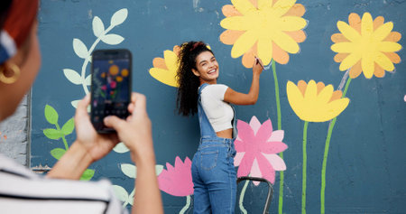 Mural, wall and picture of woman, outdoor and phone screen with art, flowers and decor for painting. Photography, painter and creative for community project, social media and people with mobile appの写真素材