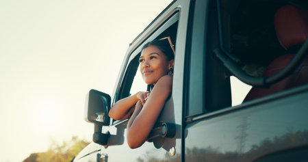 Woman, road trip and smile on travel by window for driving, journey or memory with sightseeing on safari. Person, happy and excited in vehicle, transport or reflection in summer at sunset in Colombiaの写真素材