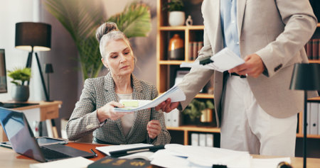 Woman, lawyer and meeting with documents in office for legal consulting, review contact and company case. Mature client, attorney and paperwork for settlement, information and procedure of managementの写真素材