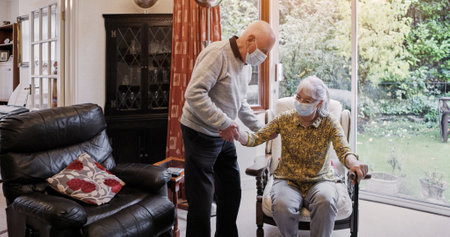 Senior, couple or help and walking stick with mask, support or assistance on sofa in living room of home. Elderly, man or woman with disability or covid in lounge of retirement with love and recoveryの写真素材