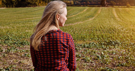 Woman, back view and field for agriculture, countryside and nature for organic, crops and fresh air. Female person, farmer or agro for sustainable development, conservation or eco friendly for silageの写真素材