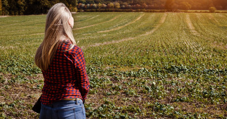 Woman, field and nature with back view in countryside for fresh air, organic and sustainable...