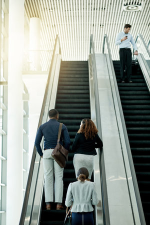 Business, group or travel on escalator at airport for global conference, flight arrival or...