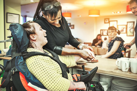 Wheelchair down syndrome disability girl patient in clinic or hospital with nurse or professional healthcare worker. Nursing and medical caregiver helping happy, friendly and young disabled personの写真素材