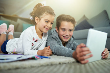 Children, happy and relax in home with tablet, online game and streaming media on homework break....