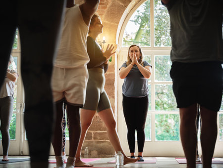 Praying, instructor teaching or women in yoga class for meditation or mindfulness in zen studio. Coach, support or calm people in pilates club for chakra energy, aura or wellness to relax togetherの写真素材