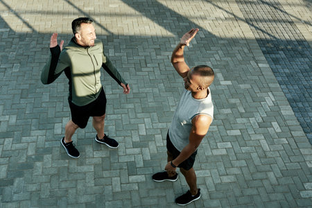 High five, athlete and celebration for friends, fitness and personal trainer with motivation for client. Outdoor, above and people with smile for accomplishment, thank you and success for workoutの写真素材