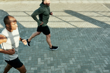 Team, above or running for city fitness, exercise or workout wellness in social sports with coach. Men, friends or personal trainer for athlete marathon, race or competition training accountabilityの写真素材