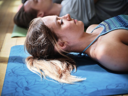 Meditation, yoga and woman in corpse pose at gym, relax and peace in mindfulness. Zen, calm people and savasana body exercise on floor, breathing for fitness and wellness, health and sleep to restの写真素材